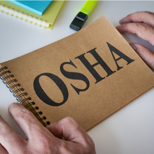Notebook with 'OSHA' printed on it held by a person's hands.